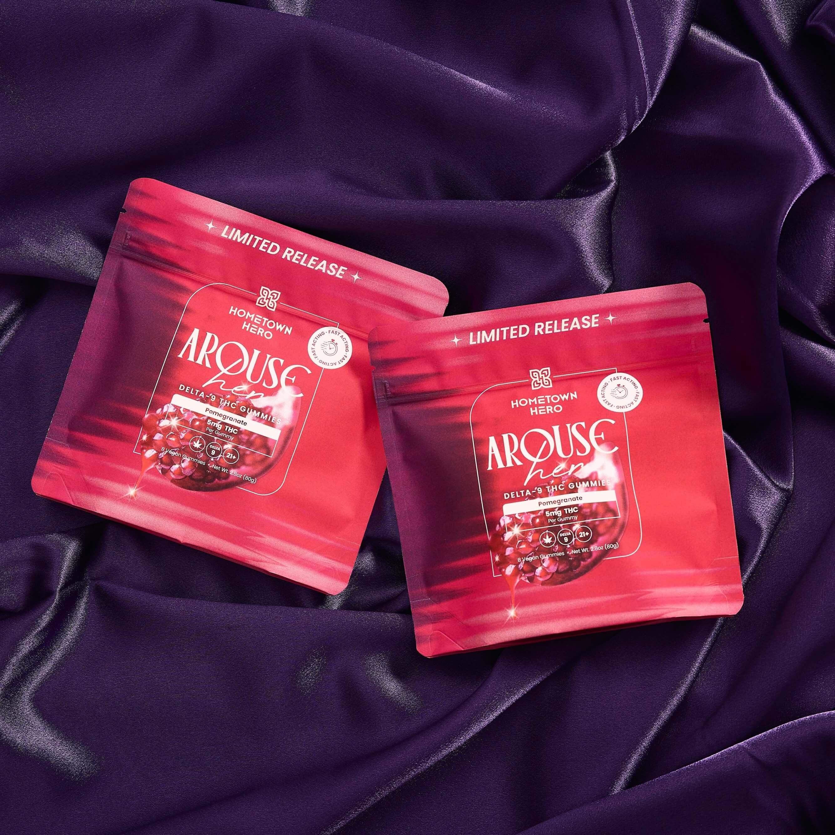 two pink bags of gummies on purple sheets