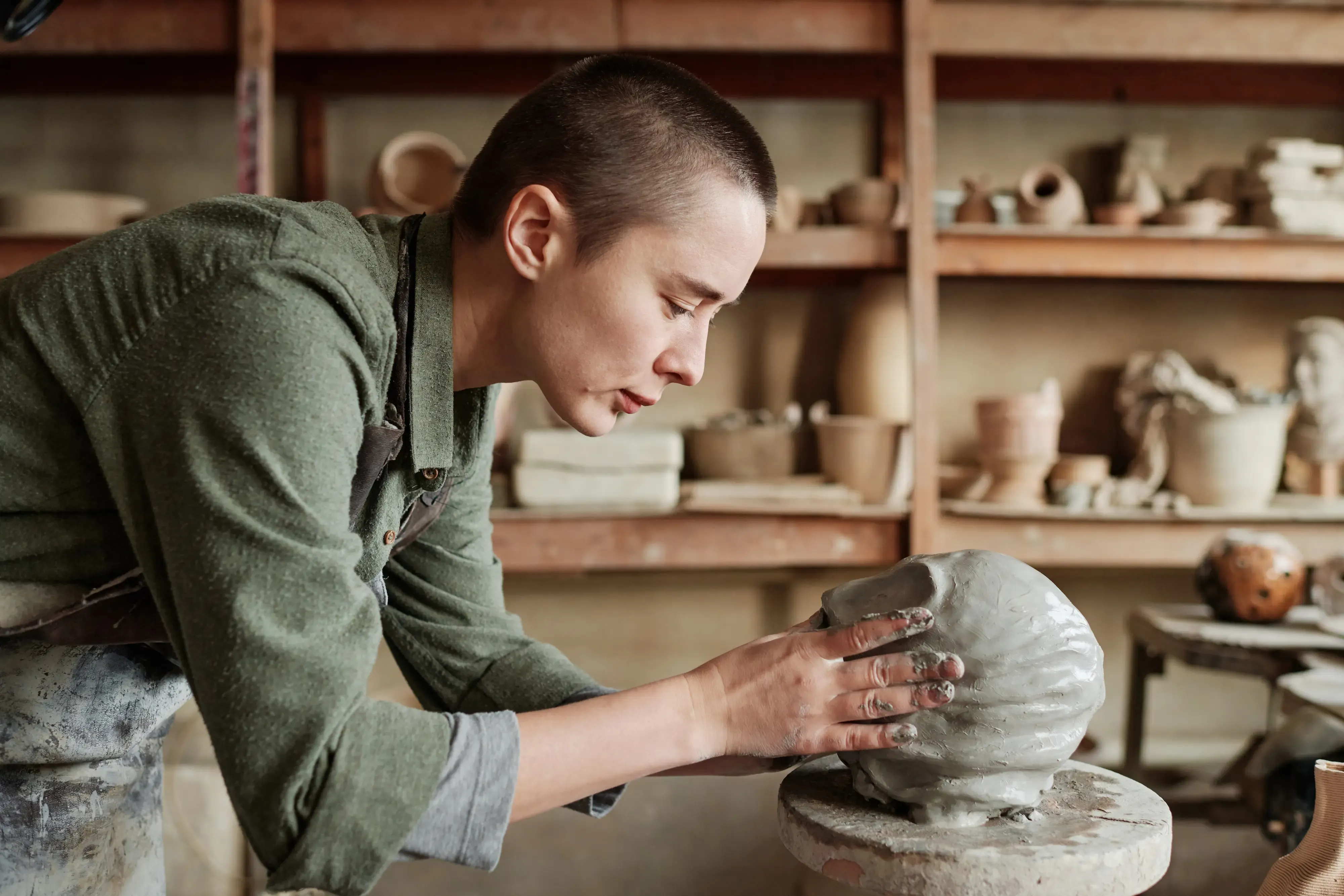 woman sculpting clay into a face